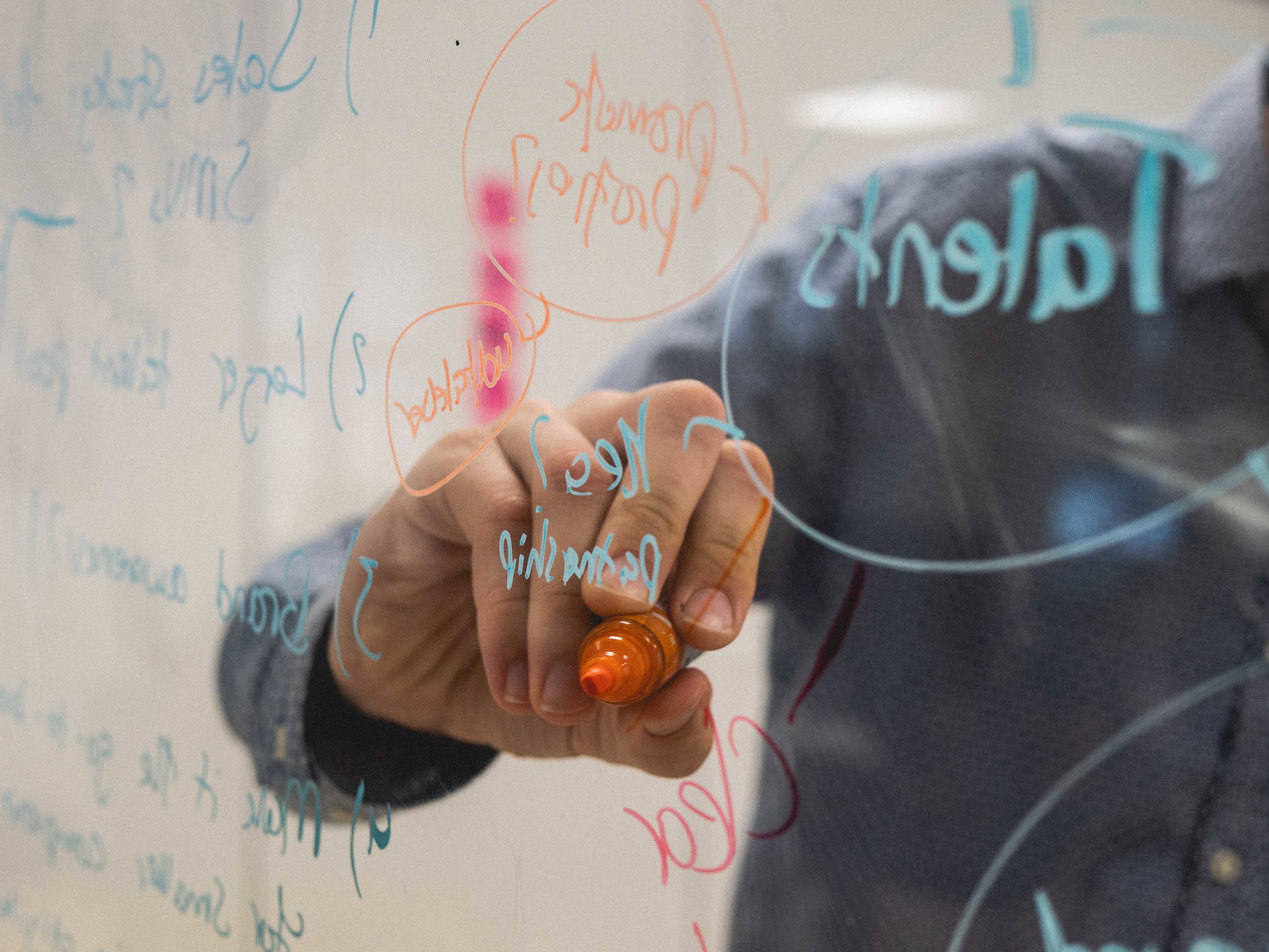 man brainstorming at white board despite downsizing