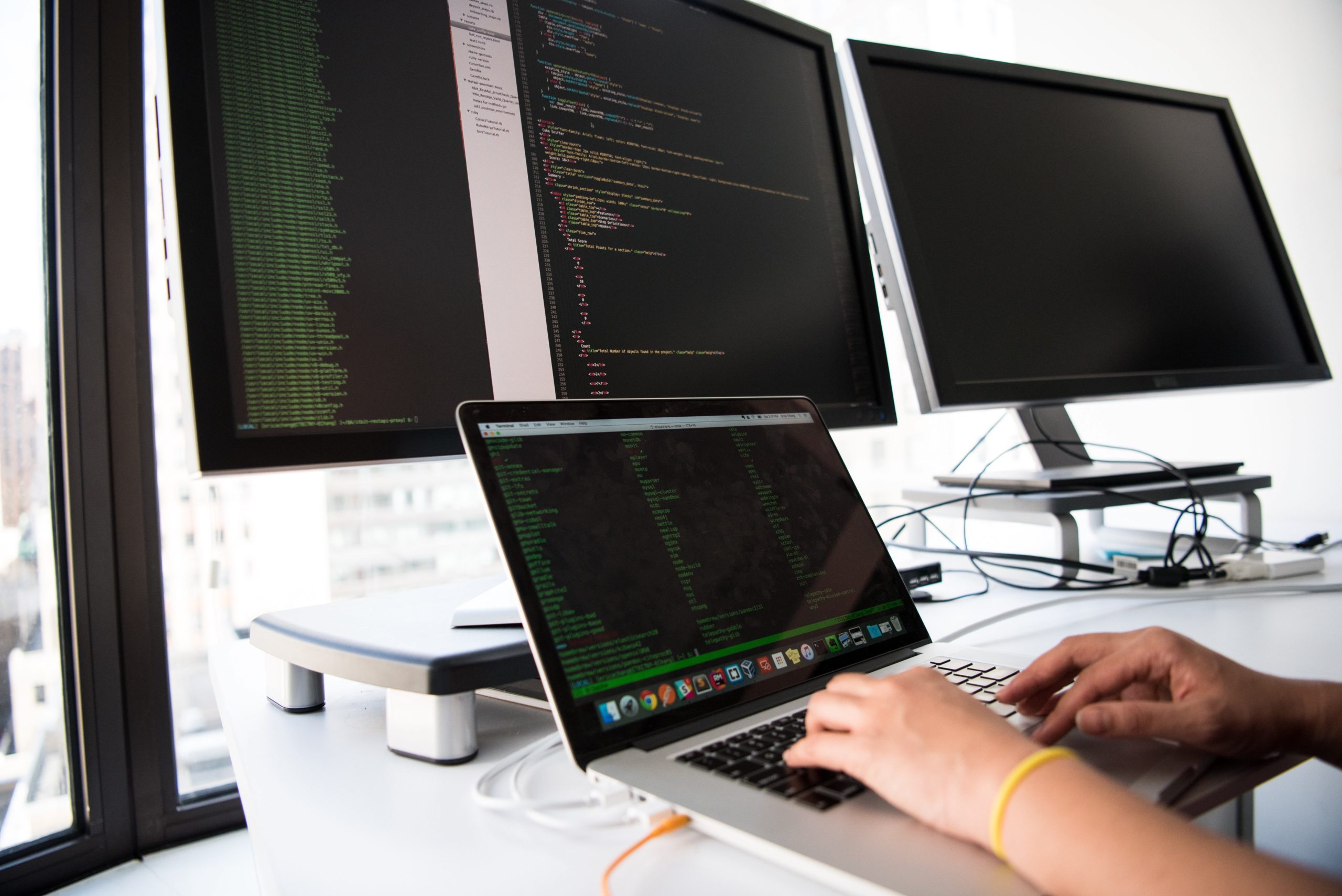 outsourced software development partner working on multiple screens